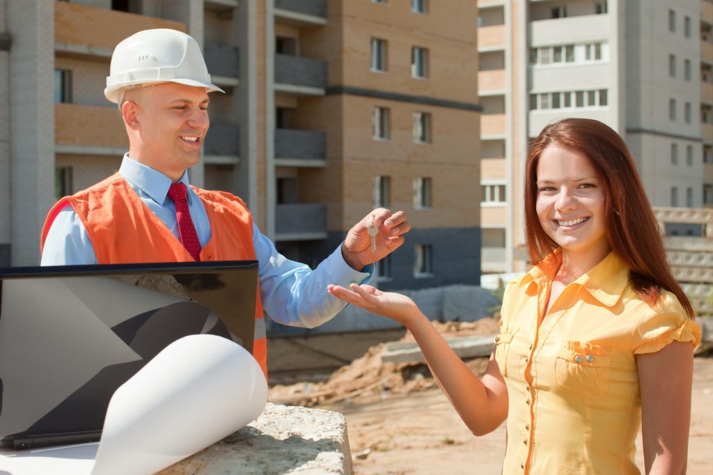 Construction worker handing over keys.